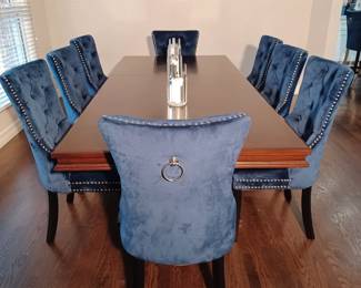 Blue Velvet Chairs with Formal Wooden Dinging Room Table that has two Leaves.