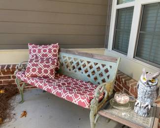 iron bench with red covers and throw pillow, side table, owl sculpture