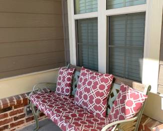 iron bench with red covers and throw pillow, side table
