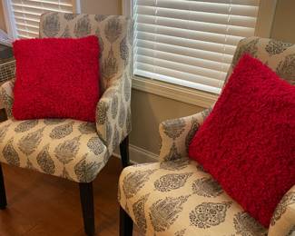 matched set white patterned armchairs with red accent pillows