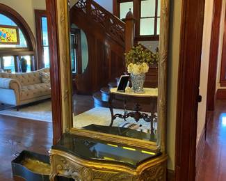 This large gold mirror is attached to an antique flower box, marble was added to  create a bench. 