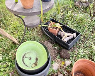 Various pots, plant stand, sprinkler, plants.