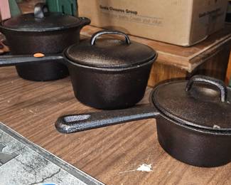 THREE CAST IRON POTS WITH LIDS