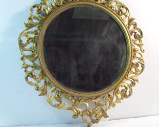 Lot 27: C/1890 Carved and gilt Italian Circular frame, 17" x  21" with original mirror and wood back.  Cond:  Mirror has some minor streaks, some wear to the gilt carvings.  Est. $75-125.