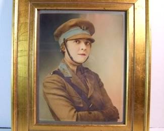 Lot 91:  C/1917 Hand tinted photo of female Military Motorcycle Courier, 10" x 13" in a wide gilt frame 17" x 20".  Cond: Light vertical crease in lower half (middle) with minor wear to the frame.  Est. $80-100.