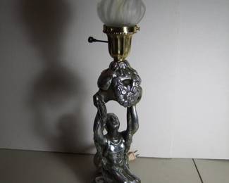 Lot 45: C/1930's Art Deco Desk Lamp, kneeling female figure holding up a torch, polished spelter, brass fitter, 21" h. x 5 1/2" x 5" w.  Cond:  Moderate wear, small hole in back near top fitter, rewired, felted bottom.  Est. $150 - 200.