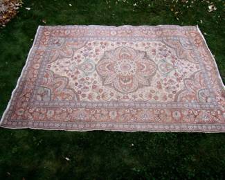 Lot 54:  Semi Antique Middle Eastern Wool Rug, floral medallion center on buff field, floral borders, 4'10" x 6" 11".  Cond: End fringes heavily worn, 3 small areas of edge wear on one long side, no stains or tears.          Est. $100 - 150.