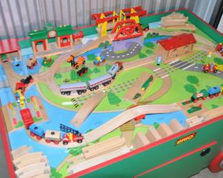 View of the Large Authentic Brio Lot ( Bridges, Tunnels, Gates, Engine Shed, Railway Station, Start Up Switch, 24 Wooden and Die Cast Trains, Trucks and Loaders, Over 55 Pieces of Wooden Train Tracks, 8People, 3 Locomotives,2 Caboos, 20 Risers, Super Supports, Bumpy Track with Eyes, and More Included in the Set ($295)