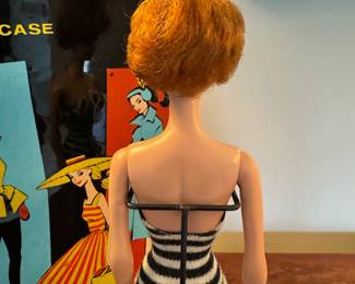 1961 Bubble Cut Titian Red Hair Barbie with original striped swimsuit, Barbie Doll Case and 10 outfits.  Outfits include ‘Evening Splendor’, ‘Friday Night Date Night’, ‘Solo In The Spotlight’, ‘Winter Holiday’, ‘Nighty Negligee’ and more.  There are a few additional accessories & shoes.  THIS WILL BE SOLD AS ONE LARGE COLLECTION. 