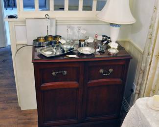 Cabinet with Wedgwood lamp and assorted pieces of pewter, silverplate, silver