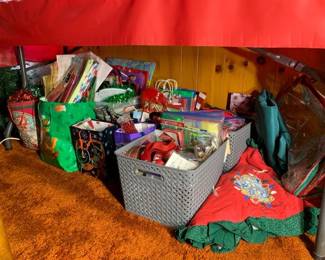 Many Christmas gift bags, ribbons, bows, cards, and other gifting supplies. 