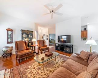 Living Room View #3 Wing Back Chairs, Suede Sofa, Fish Bowl & Wall Clock in Background
