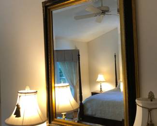 Elegant Mirror hanging above Dresser in Master Bedroom surrounded by more Brass Lamps
