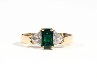 EMERALD & DIAMOND 18K LADY'S RING | Yellow gold ring size 7-3/4, consisting of an emerald-cut emerald approx. 1 ct., flanked by 2 trillion-cut diamonds, each approx. 0.2 ct., signed 18k, 6.7g