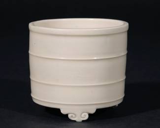 CHINESE DEHUA PORCELAIN TRIPOD CENSER | Chongzhen period (1628-1644), of cylindrical shape with lipped rim, three bowstring bands, an impressed key-fret band around the center, and three ruyi-head feet, all covered with an even, ivory-white glaze, old labels for L. Michon, Paris and Robert McPherson
h. 2-5/8 dia. 3 in.