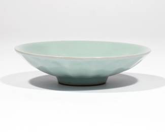 CHINESE LONGQUAN CELADON SAUCER | Song dynasty (960-1279), shallow bowl with slightly lobed 'chrysanthemum' exterior, covered in a bluish-green glaze. dia. 5 in.