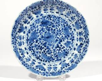 CHINESE KANGXI BLUE & WHITE PORCELAIN DISH | Kangxi reign (1662-1722), decorated with a central peony among prunus and other flowers on a floral ground, with Lingzhi mark, with old gallery labels
h. 1-3/8 dia. 8-1/4 in.
