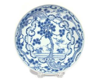 CHINESE BLUE & WHITE PORCELAIN DISH | Qing dynasty (1644-1911), depicting a pine with two cranes, one poised in flight, the other standing, in a springtime landscape, and an additional two cranes with pine in flight among clouds around the borders, with apocryphal Xuande reign mark within a double circle. h. 1-7/8 dia. 8-1/4 in.