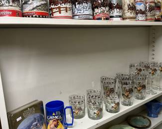 Many BUDWEISER beer steins to choose from.  Assorted glassware and a CAMEL cigarette mug