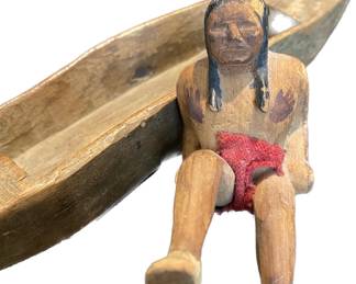 Hand carved Native American figurine in carved wooden canoe