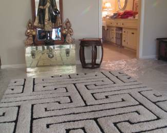 Plush area rug, cedar lined brass chest, shape mirror, barrel stool