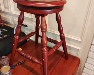 Very solid Cherry Color rotating piano bench.  Does NOT elevate.