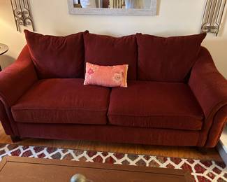 Burgundy Couch with Mirror and Wall Hangings