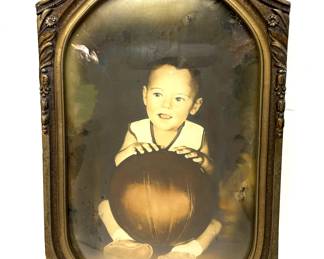 1930s framed photo of a little boy sitting with a basketball 