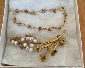 18k gold bracelet (top in photo); 14k gold brooch.