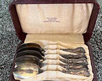 Set of five sterling spoons in case.