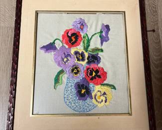 Framed needlework, flowers in vase.