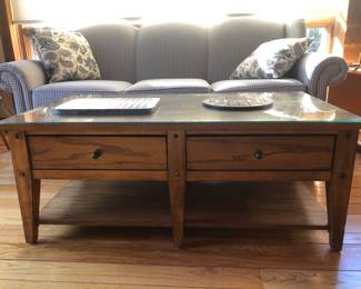 Coffee table is made of wood... real wood NOT SYNTHETIC... has double sided drawers... with a glass protection cover to preserve the wood