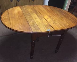 An oak drop-leaf table takes little space when the leaves are down. 
