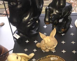 A couple of bunnies pose with a variety of unicorns both large and small.