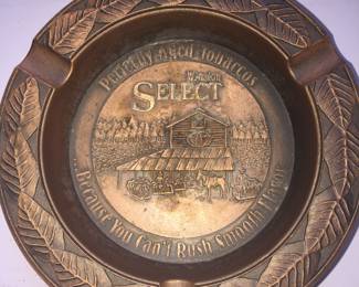 An older Winston cigarette ashtray made of metal. 