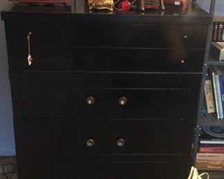 Jet black color adds a dramatic flair to this chest of drawers. 