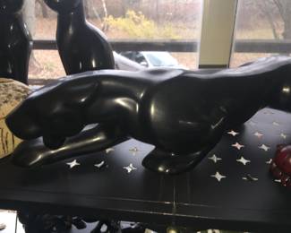 A vintage black panther stalks amid domestic cats and other creatures. 