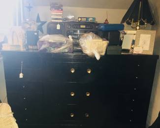 A dresser matches a chest of drawers and double-bed frame. A touch lamp, boom box on steroids, decorative items and more share space on top. 