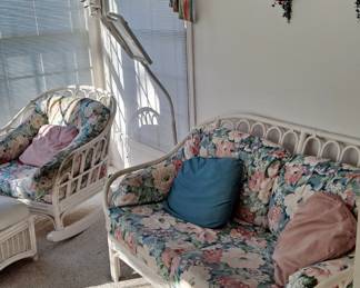 White Wicker Set with Floral Upholstery: One Chair, One Rocking Chair and a Love Seat, including a multiple Side / End Tables; and Silk Plant(s), and an Ott-Style Lamp.