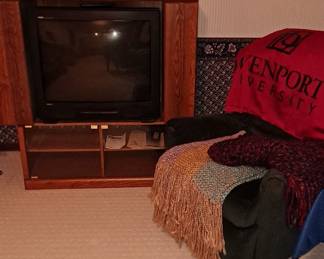 Wood Media Cabinet; Small Fan; Large Box TV; Vintage Video Cases; Silk Plants; Recliner; Davenport University Blanket; & Afghan