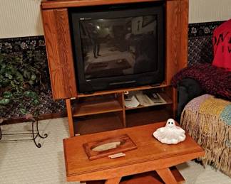 Wood Media Cabinet; Small Fan; Large Box TV; Vintage Video Cases; Silk Plants; Tray Table; and assorted room decor.