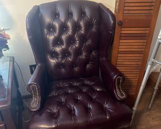 Wine colored leather chair in first bedroom on left