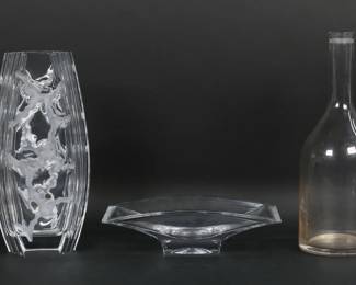 135	5 Piece Modern Crystal Lot Tiffany, Baccarat, Hoya	5 pieces modern crystal. L'Atelier du Vin decanter, 11 1/2"H; Tiffany decanter, 9 1/2"H; Baccarat vase, 8 1/2"; Nambe bowl, 9 1/4"L x 2 1/2"H; Hoya vase, unsigned, 10 1/2"H. Baccarat vase small chip at top corner.
