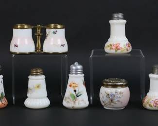 28	13 Pieces Opaque Glass Including Wave Crest	13 pieces opaque glass, including Wavecrest. Most with hand painted floral decoration. Jar with monogrammed hallmarked sterling silver lid, jar with silver tone lid, lidded box, 8 salt and peppers including 2 pairs, cabinet vase, "binocular" double vase. 2 jars both with red Wave Crest banner marks, others all unmarked. Jar with sterling lid 3 5/8"H. Salt and peppers all with mismatched tops, tops all bent and dented, salt and peppers all with chips to the rims, losses to decoration on salt and peppers.

