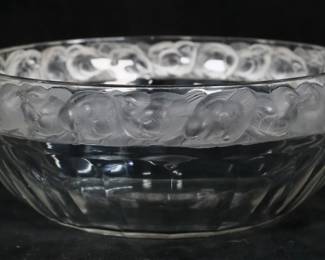 224	Lalique Mesanges Crystal Bowl	Signed Lalique France Mesanges crystal coup bowl. Clear glass with a frosted rim of birds in relief. Signed on the underside. 3 5/8"H x 9 1/8"-diameter. Chips and fleabites to the rim, chip to one side, chip to the underside.
