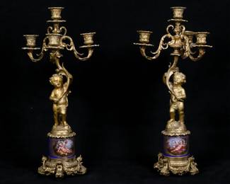 307	Pair of Sevres Style Gilt Bronze Candelabra	Pair of Sevres style porcelain and gilt bronze figural candelabra. Hand painted scenes with putti and flowers on the reverse, gilt bronze putti supporting four light candelabra. Unsigned. Each 20"H. Arms bent on one, minor losses to gilt patina.
