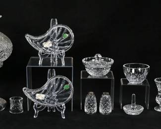 428	11 Pieces Waterford Crystal	11 pieces signed Waterford. Lamp with hurricane shade, pair of leaf dishes in original boxes, pair of salt and pepper shakers (no tops), napkin ring, small vase, ashtray, ring tree, small bowl, bowl, additional lid. Lamp 14 1/4"H, leaf dishes, each 7 1/4"L. All with etched Waterford marks. Chips to rim of vase, fleabites to lamp, chip to rim of lamp base.
