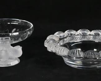 225	2 Pieces Lalique Pornic & Nogent	2 pieces signed Lalique crystal. Pornic bowl with scalloped sea shell rim, signed Lalique France, 2"H x 7 3/4"-diameter; Nogent footed bowl, clear glass with frosted bird pedestal, signed Lalique France, 3 3/8"H.
