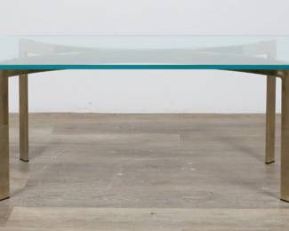 162	Hollywood Regency Style Cocktail Table	"Hollywood Regency style cocktail table. 20th century. Beveled glass top, brass base. Small chip to glass on one edge. Light scratches and scuffs to glass. Light tarnishing, scuffs and wear to brass.

48"" W x 20 1/8"" D x 16"" H. 60 lbs."
