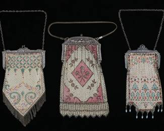 236	3 Mandalian Mesh Bags	3 signed Mandalian Mfg. Co. mesh purses. Beige with pink and brown floral decoration, silver tone frame with roses and jeweled button clasp; beige with green, purple and orange geometric art deco decoration; beige with orange, black and green art deco geometric and floral decoration and enamel teardrop fringe. Bag with rose frame 8"L. Beige and pink bag frame slightly bent at top, beige bag with teardrop fringe missing section of mesh on one side and some losses to enamel on sides and throughout.
